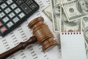 money, calculator, gavel and spreadsheet representing hoa dues post bankruptcy