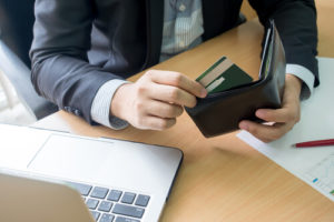Man contemplating money in wallet during bankruptcy